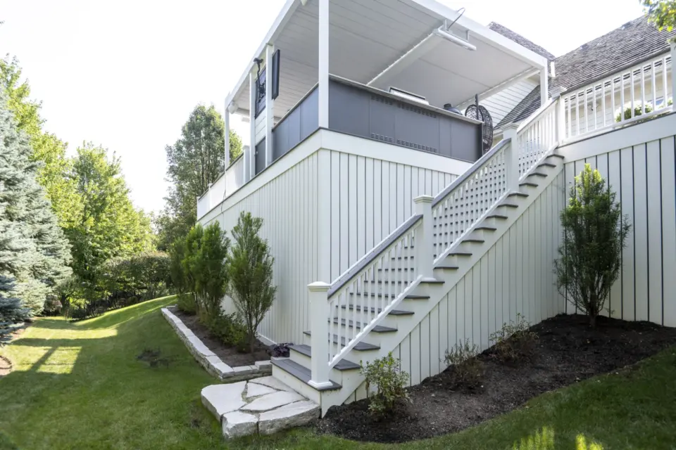 25 stairs leading up to white aluminum Corradi Alba pergola above outdoor kitchen and TimberTech Castle Gate cellular pvc deck