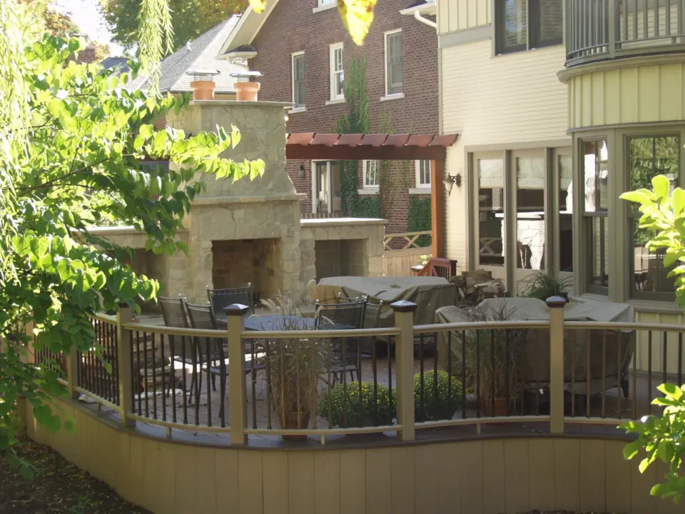 41 Curved TimberTech Premier railing with Dark Copper Vein powder coated aluminum cap lights and balusters with large stone fireplace